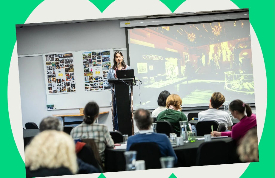 Woman speaking at a podium at unspecified heritage interpretation event.