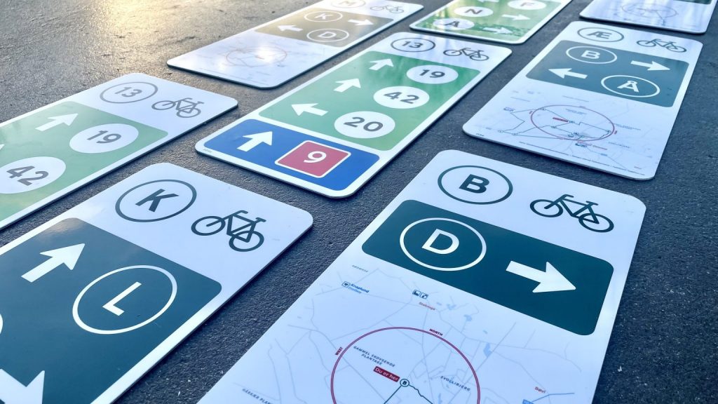 A variety of Danish road signs (aimed at cyclists) laid out on a road surface