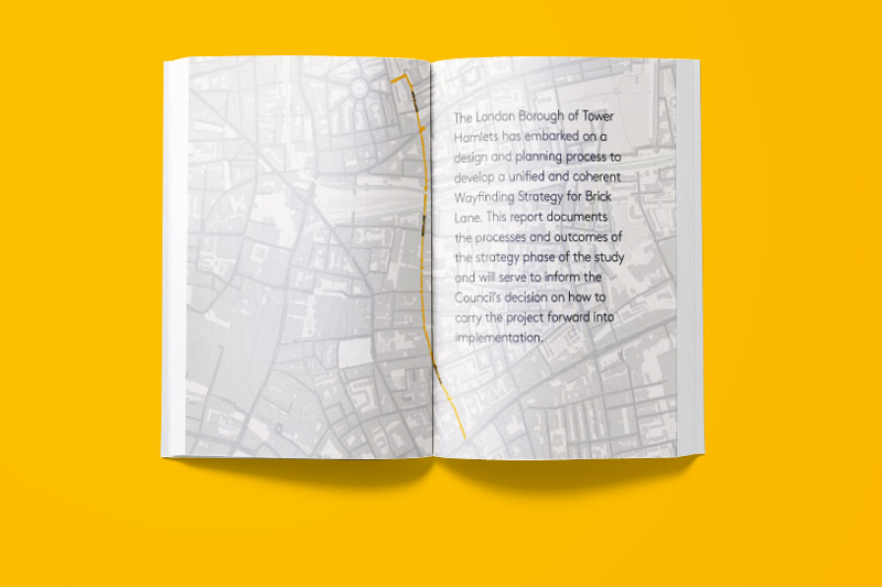 Open book showing writing on the right hand page and a map on the left hand one, against a buttercup yellow background