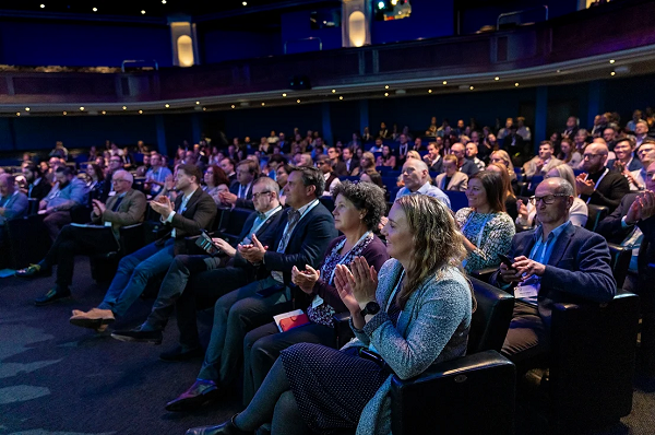 View of the audience at a conference, clapping.