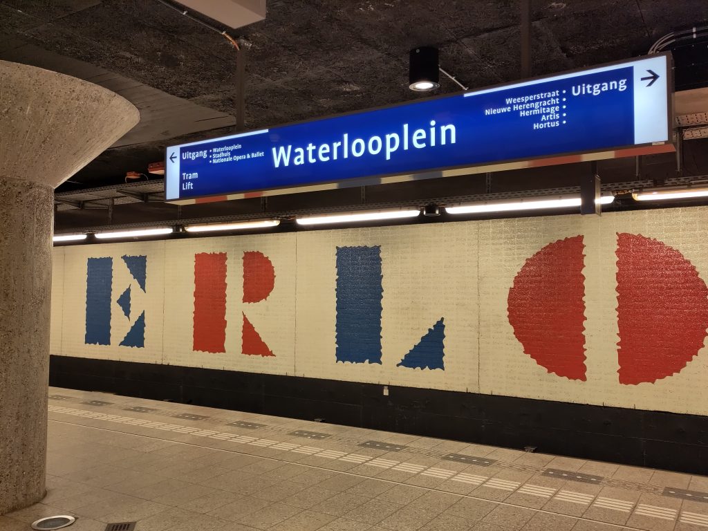 Signage for the Amsterdam Metro (the Netherlands) station, Waterlooplein above a white, red and blue tiled wall