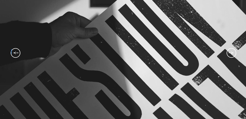 B&W photo showing a left hand holding up a poster of typography