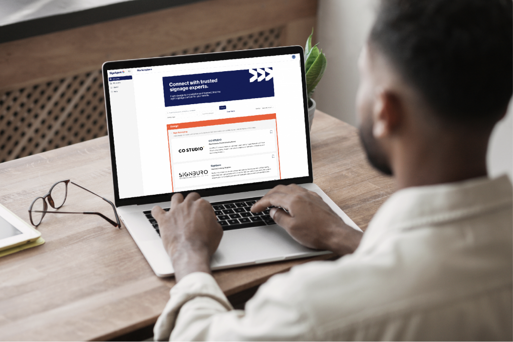 Man sitting working on his laptop at a desk indoors