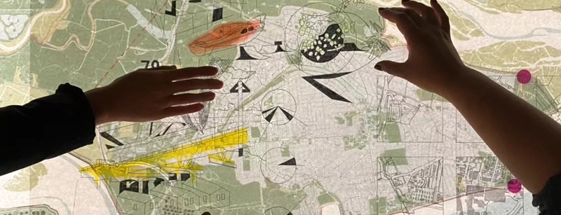 Two right hands moving things around over a digital map screen.